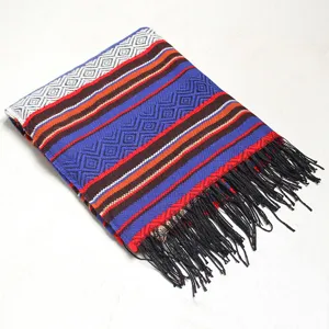 Detailed view of a thick woven geometric blanket scarf with vibrant stripes and black fringes.