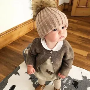 Bonnet tricoté chaud d'hiver pour enfant vue de détail avec pompon duveteux en intérieur