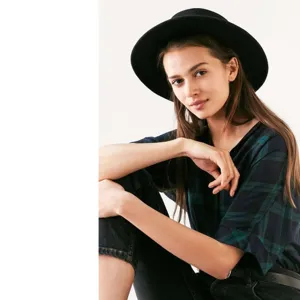 Detail view of the stylish black fedora hat worn by model, showcasing premium texture and brim design.