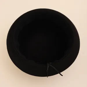 Close-up detail view of the inner lining and adjustable drawstring of a black wool felt basin hat.