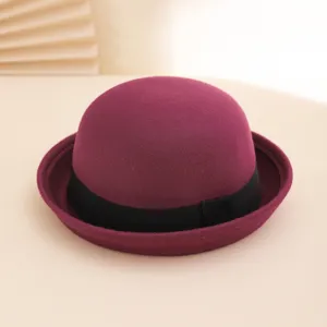Burgundy wool felt bowler hat close-up, showing fine texture and elegant black ribbon band.