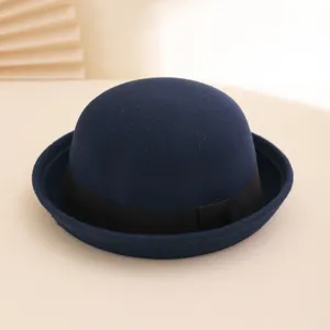 Detailed view of dark blue wool felt bowler hat with black band, autumn winter fashion accessory.