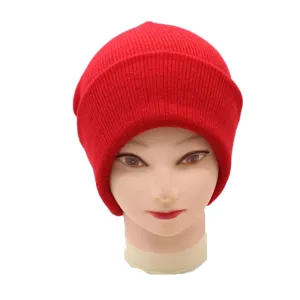 Vue détaillée d'un bonnet en tricot rouge vif pour femmes et hommes au design uni classique.