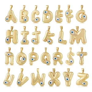 Detailed view of gold-plated evil eye alphabet letter pendants with sparkling clear crystal stones.