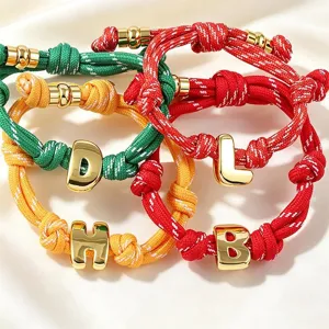 Bracelet tressé coloré avec breloques de lettres dorées, accessoire de mode tendance chic.