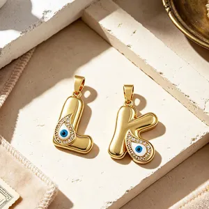Detailed close-up of 18K gold plated evil eye initial letter pendants with sparkling zirconia.