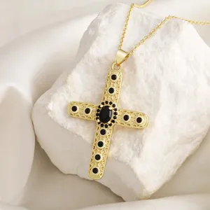 Elegante goldene Kreuz Halskette mit schwarzen Steinen und Vintage Design für Damen.