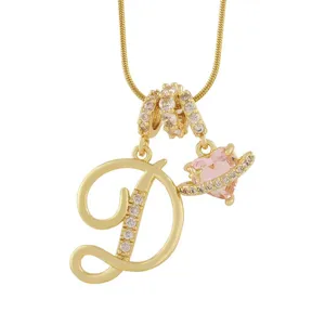 Gros plan du collier pendentif lettre D en or avec planète cœur rose et détails en zirconium.