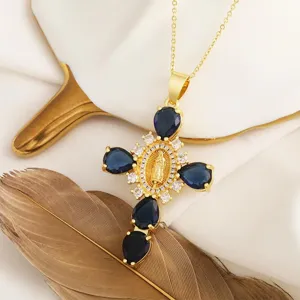 Dettaglio della collana con ciondolo a croce in oro 18K con zirconi blu e ritratto in rilievo.