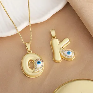 Gold plated evil eye letter C necklace and K pendant detail view featuring blue cubic zirconia.