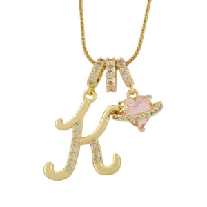 Collier lettre K élégant avec pendentif cœur rose et zircone cubique scintillante.