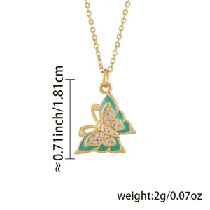 Nahaufnahme des goldenen Schmetterlingsanhängers mit Türkis-Emaille und glänzenden Zirkonen.