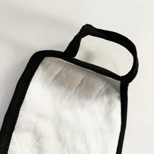 Nahaufnahme des weißen gesteppten Staubschutzmaskendetails mit schwarzen Ohrschlaufen.