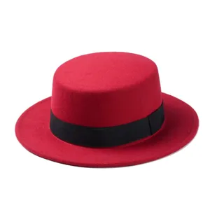 Red felt flat top hat with black ribbon band, classic vintage British style jazz hat detail.