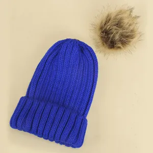 Détail en gros plan de bonnet tricot d'hiver pour enfants avec pompon en fausse fourrure.