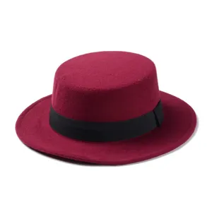 Detail view of a stylish wine red wool flat top hat with black ribbon band close up.