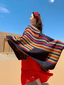 Ethnic style colorful stripe shawl detail, outdoor desert scene, warm winter cape view.