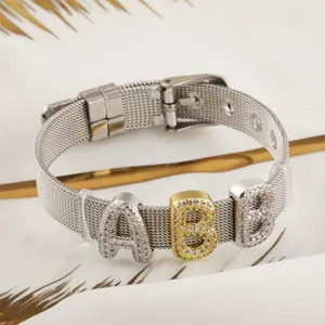 Gros plan détaillé du bracelet en maille avec breloques lettres et zirconiums.
