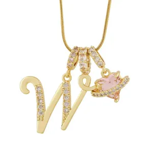 Vue détaillée du collier pendentif lettre plaqué or avec zircons étincelants et charm cœur rose.