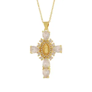 Collana con ciondolo a croce placcata in oro dettaglio con zirconi e figura religiosa al centro.