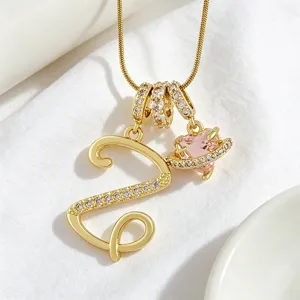 Collier pendentif lettre dorée et cœur rose Saturne vue détaillée avec pierres zircon.