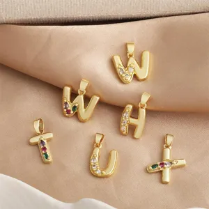 Gros plan détaillé de pendentifs lettres de l'alphabet et symboles en cuivre zircon coloré.