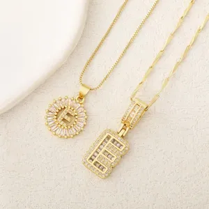 Set de collar con colgante de letra E de latón bañado en oro con circonitas brillantes.