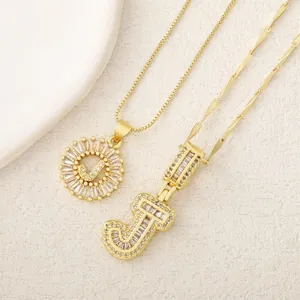 Primer plano detallado de los collares con letras J doradas y circonitas brillantes.