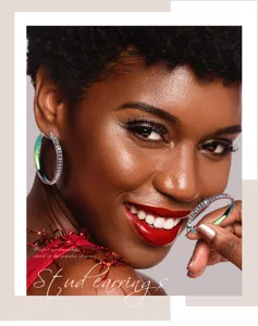 Close up of shiny rainbow rhinestone hoop earrings worn on model, stylish and vibrant design.