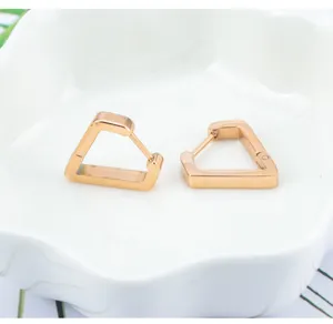 Primer plano detallado de pendientes de aro geometricos poligonales de acero inoxidable.