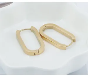 Detail view of minimalist oval gold stainless steel hoop earrings, vintage chic titanium jewelry.
