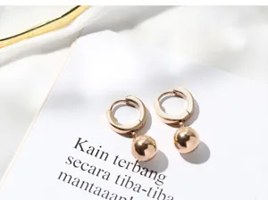 Detailed view of minimalist rose gold round bead hoop earrings crafted in stainless steel.