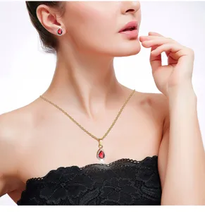 Gedetailleerde close-up toont rode zirkoon druppel ketting en oorbellen op mooi model.