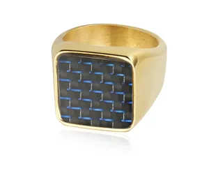Primer plano detallado del anillo sello para hombre de acero titanio dorado con incrustación carbono.