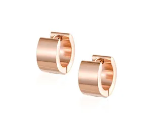 Detalle de pendientes de aro gruesos de oro rosa, joyería de acero inoxidable liso.