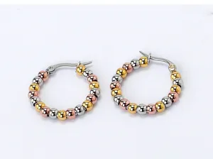 Detailed close-up of colorful steel hoop earrings featuring small beads in gold, silver and rose gold.