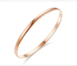 Gros plan de détail sur le bracelet jonc fin et lisse en acier inoxydable or rose.