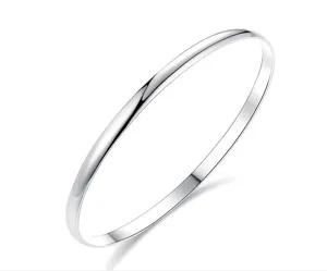 Gros plan détaillé d'un bracelet jonc lisse en acier inoxydable argenté poli brillant.