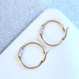 Pendientes de aro de acero inoxidable con baño de oro y brillantes detalles de cristal.