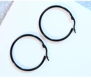 Close-up detail of black stainless steel hinge hoop earrings, minimalist punk design.