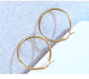 Nahaufnahme Detail klassischer goldener Edelstahl-Creolen, einfaches und stilvolles Design.
