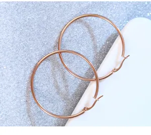 Detailed shot of rose gold stainless steel large hoop earrings showcasing minimalist circular design.