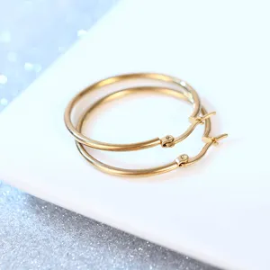 Klassische goldene Edelstahl Creolen fuer Damen, trendiger minimalistischer Schmuck.