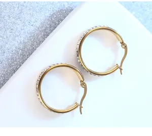 Stainless steel gold-plated round hoop earrings with sparkling white rhinestone crystals.