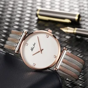 Primo piano di orologio da donna minimalista con quadrante bianco, indici in cristallo e cinturino.