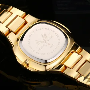 Gold wristwatch detail view showing stainless steel case back, engraved text and metal link strap.