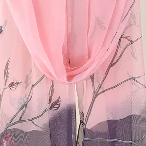Primo piano dettagliato del tessuto in chiffon leggero con stampa di rami rosa.