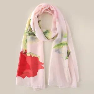 Close-up detail van de roze chiffon sjaal met levendige rode rozenprint en zachte stof.