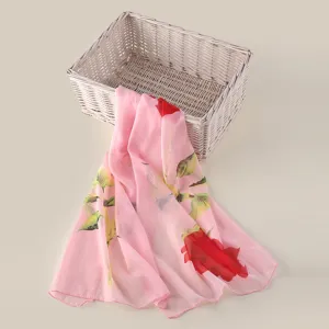 Gedetailleerd uitzicht op een roze chiffon sjaal met een prachtig rozenbloemenprint.