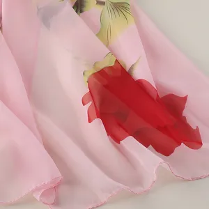 Detailopname van de roze chiffon sjaal met een levendige rode roos en groene bladprint.